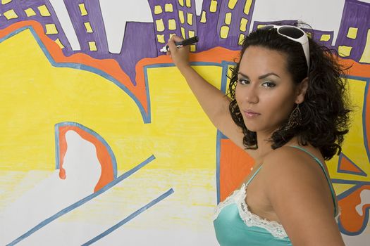 Twenty something latino women sitting in front of a graffiti