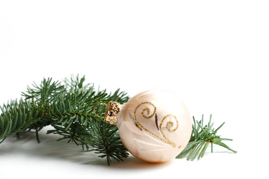 A fir branch and a christmas ball isolated on white background