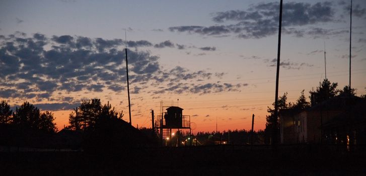 sunset in the orange sky setting over prison yard 