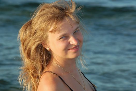 Beautiful blond girl stands near the river