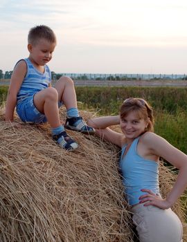 Mom and their boys lying down and having fun in the grass 