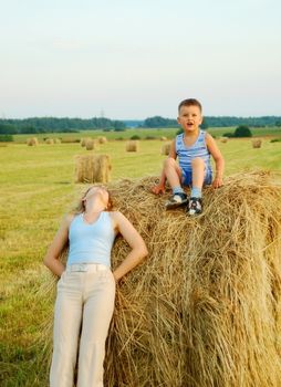 Mom and their boys lying down and having fun in the grass 