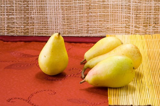 Sweet pears on a table covered with crimson cloth