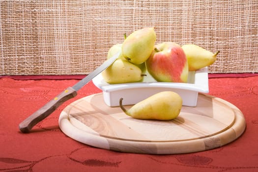 Sweet pears on a table covered with crimson cloth