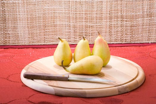 Sweet pears on a table covered with crimson cloth