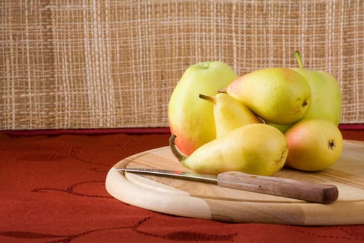 Sweet pears on a table covered with crimson cloth