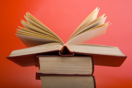 Old books with red cover on a red background