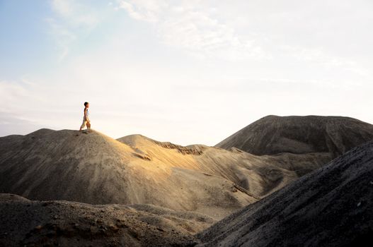 young man go up in sand desert in sundown