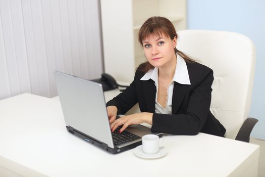 The young woman works with the computer at office