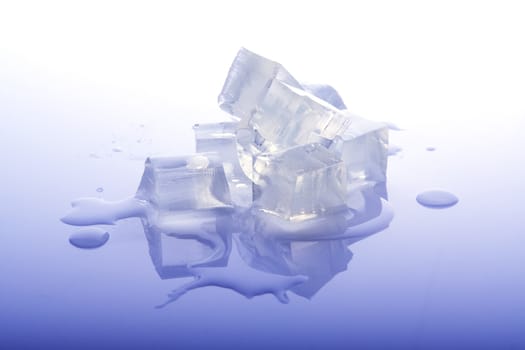 Ice cubes on surface with water drops and reflections