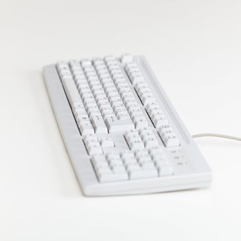 The computer keyboard lies on a table surface