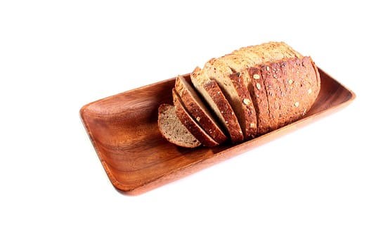 The cut grey bread in wooden long plate on white background.