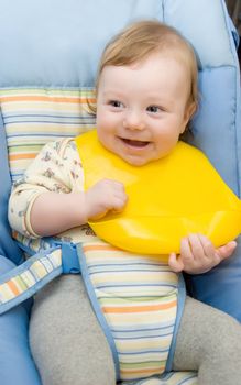 Cute baby boy ready to feeding sitting in his baby chair