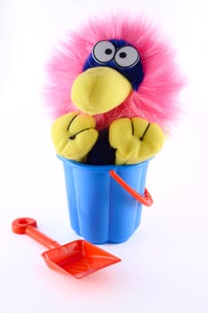 Toy sitting in a dark blue bucket with a red scoop removed close up