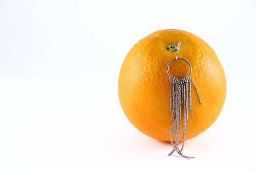 Orange with an earring removed on a white background close up. Not isolated