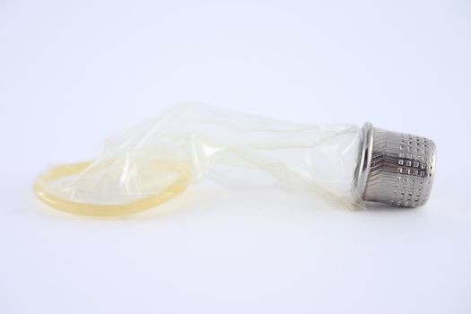 Condom with a thimble removed on a white background close up. Not isolated