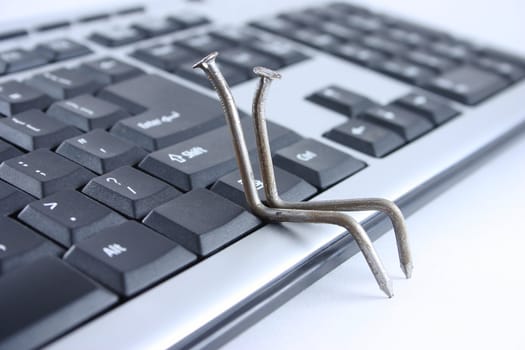 Two nails sitting on the computer keyboard removed close up