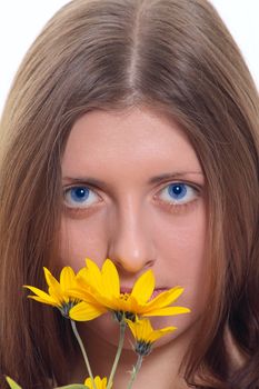 Portrait of the blue-eyed girl with a yellow wild flower removed close up