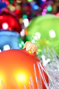 New Year's fur-tree toys against a multi-coloured tinsel removed close up