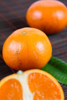 Three tangerines on a bamboo napkin removed close up