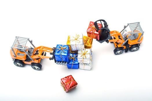 Model toy trucks shifted gifts wrapped in shiny colored paper and tied with gold rope