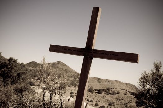 Sepia image of desert landscape and large wooden cross