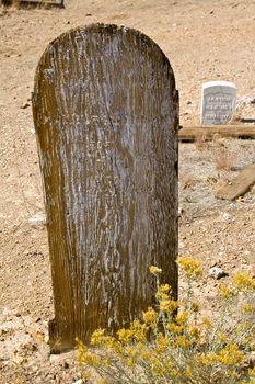 Old weathered wooden grave marker in desolate landscape