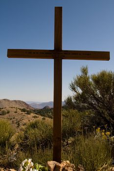 Large wooden grave marker in desert scrub landscape