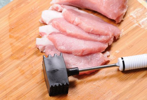 The cook prepares a chop from pork