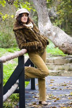 girl posing on wooden bridge in autumn