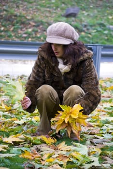 beautiful girl holding colorful autumn leaves in hands