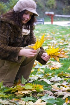 beautiful girl holding colorful autumn leaves in hands