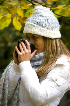 cute girl drinking hot tea in cold autumn