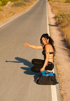 Sexy hitchhiker hoping for a lift on a lonely road