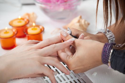 Beautician cutting artificial acrilic fingernails. Close-up shot