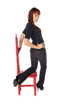 attractive redhead on a red chair against a white background