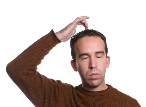 A man wearing a sweater is doing the "emotional freedom technique" by tapping on the top of his head, isolated against a white background