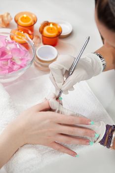 Beautician applying gel on fingernails. Close-up shot