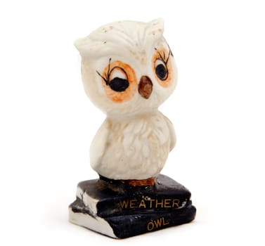 An old ceramic weather owl that changes color depending on the weather, isolated against white.