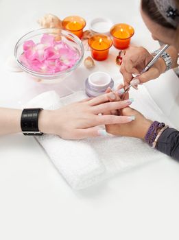 Beautician applying gel on fingernails. Close-up shot