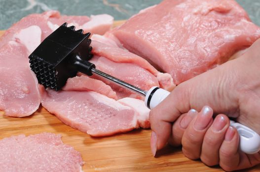 The cook prepares a chop from pork