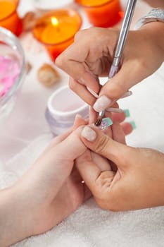 Professional beautician applying gelon fingernails. Close-up shot
