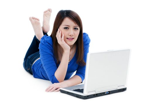 Portrait of a beautiful young woman lying on the floor with laptop over white background.