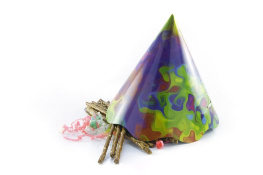 Salty brown tasty pretzels with cone shaped party hat and streamers on a reflective white background
