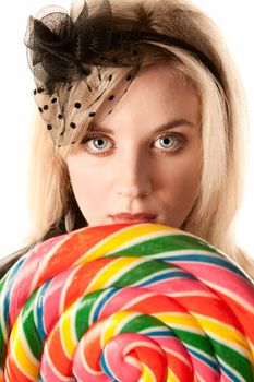 Pretty young blonde woman with large colorful lollipop