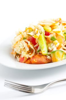 Fresh salad in a plate with a defocused fork in front