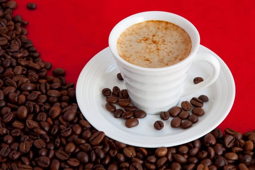cup with coffee and grain expressed on red background
