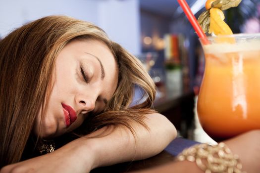 Tired beautiful women with cocktail in hand