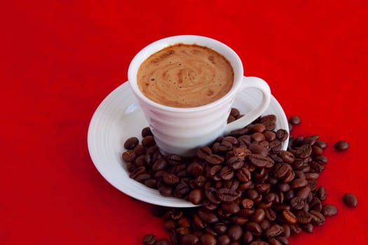 cup with coffee and grain expressed on red background