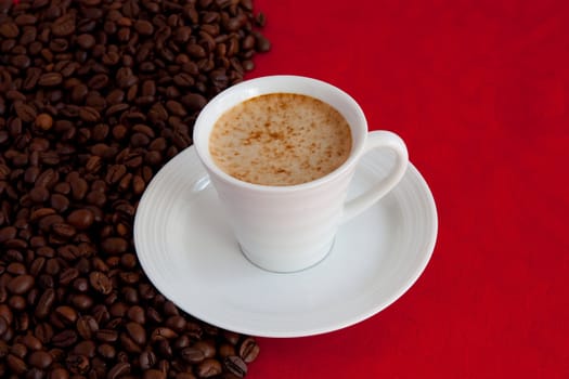 cup with coffee and grain expressed on red background